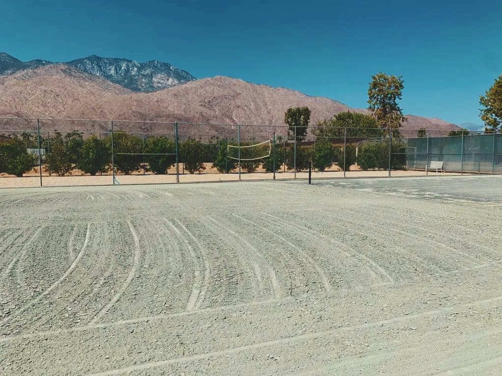The same court with its clay surface cut in long curved passes